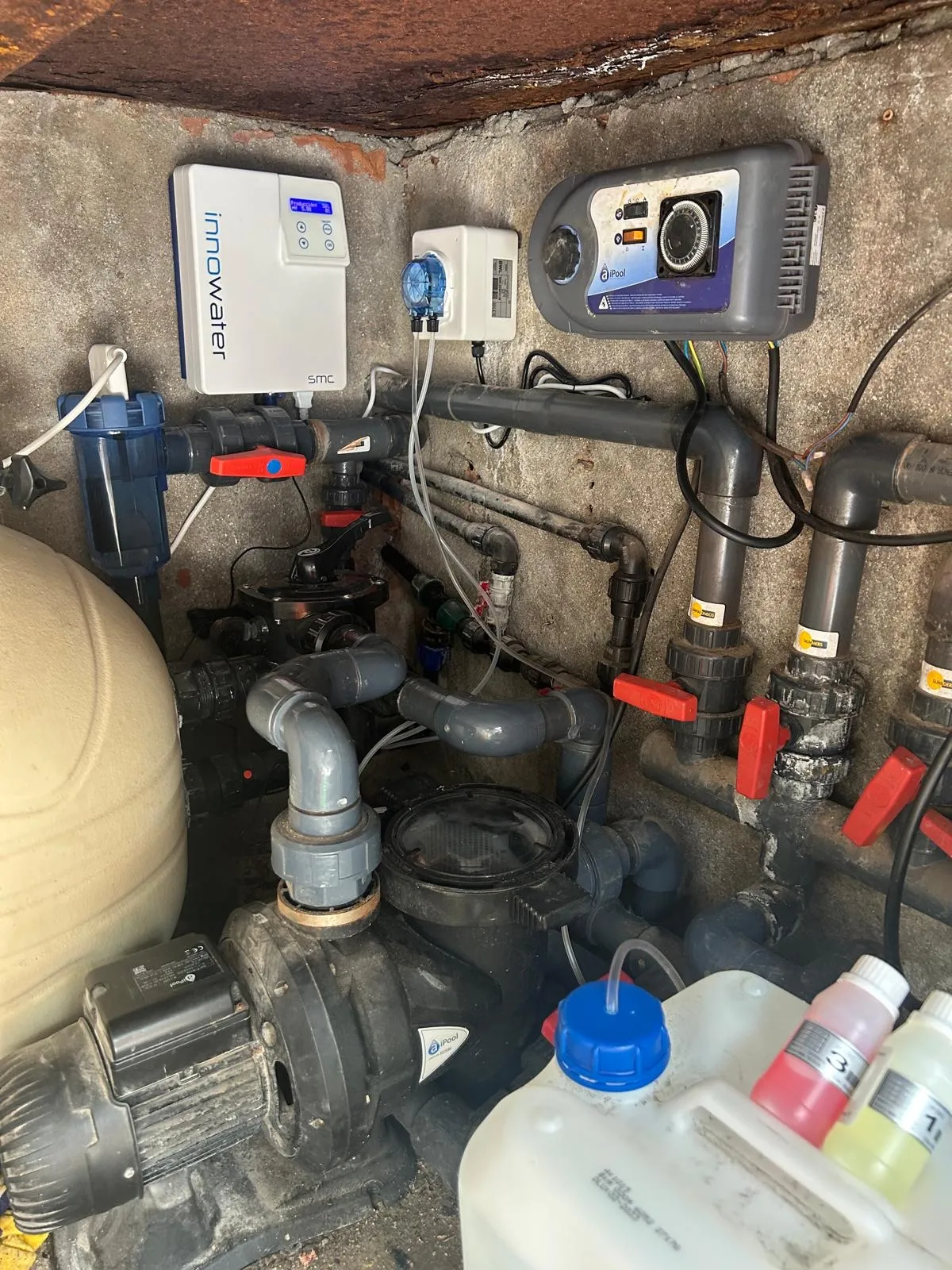 Cuarto técnico con filtro de arena, bomba y garrafas de producto
