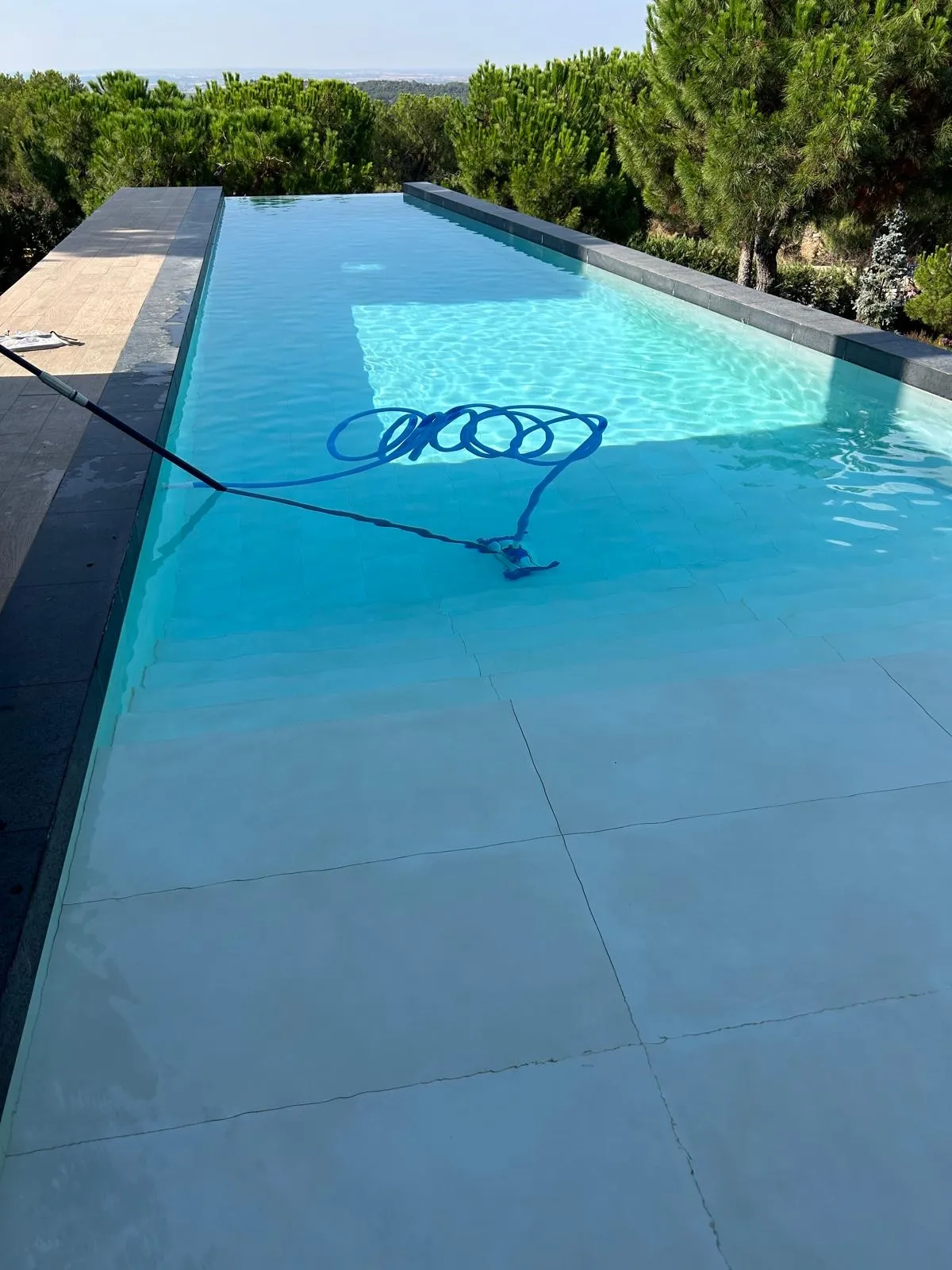 Piscina con el limpiafondos trabajando