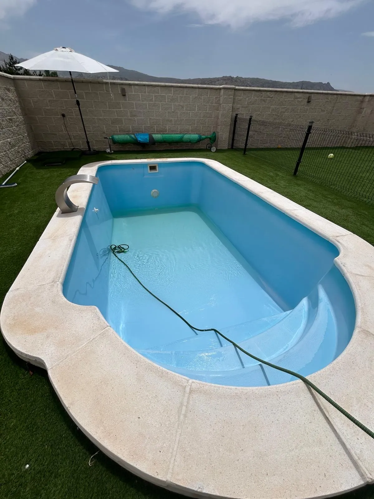 Piscina prefabricada en un jardín, limpia y a punto